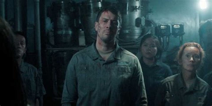 A battered and bloody Miles surrounded by his fellow workers