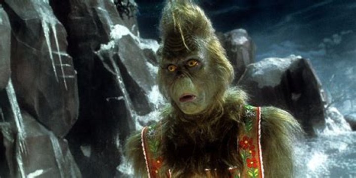 A shocked Grinch wears traditional garb