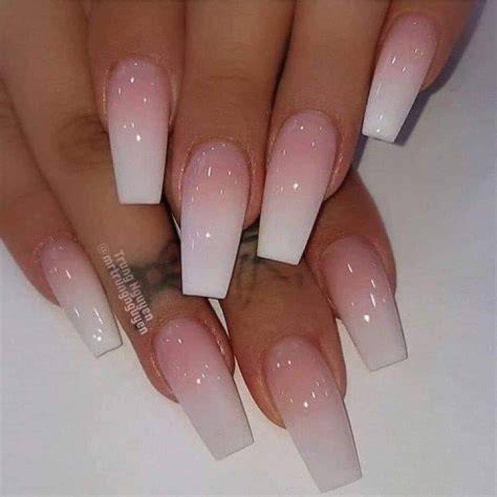 Acrylic nail being shaped with a brush