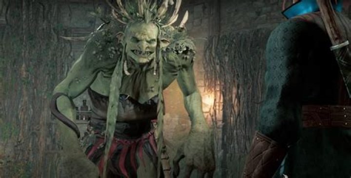 Auntie Ethel's hag form in Baldur's Gate 3 smiles with her sharp teeth and pale green skin.