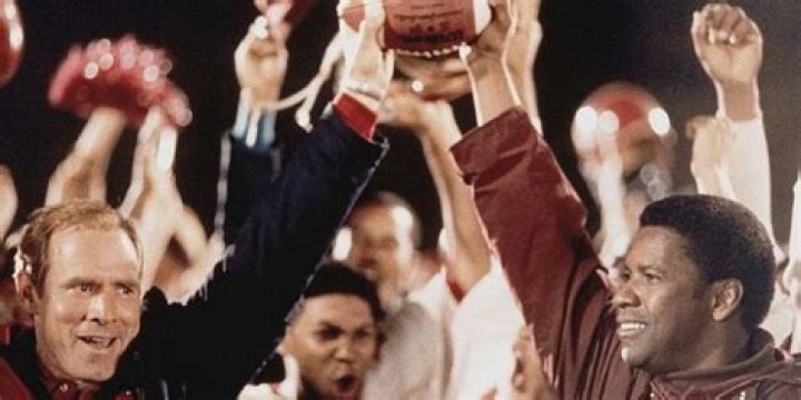 Coach Yoast and Coach Boone holding up a football in Remember the Titans.