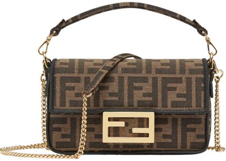 Fendi baguette bag with logo print against off-white denim jacket
