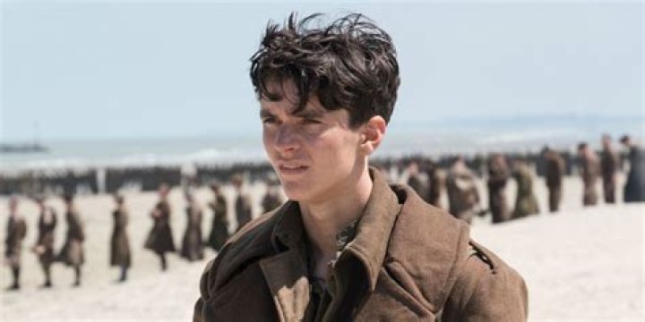 Fionn Whitehead standing on the beach in Dunkirk