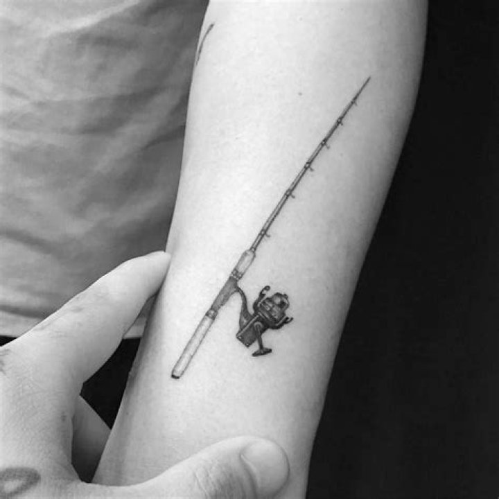 Fishing pole tattoo on the forearm.