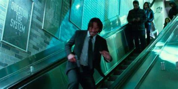 John Wick running down an escalator in John Wick