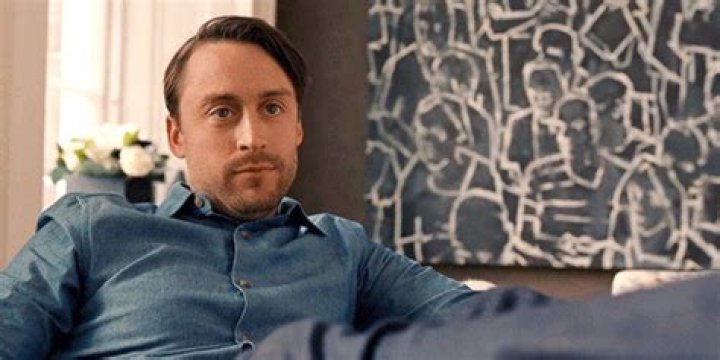 Kieran Culkin as Roman sitting on a chair looking smug in Succession