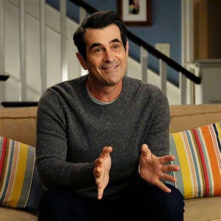 Modern Family - Phil Dunphy showing off his hand gloves on TV