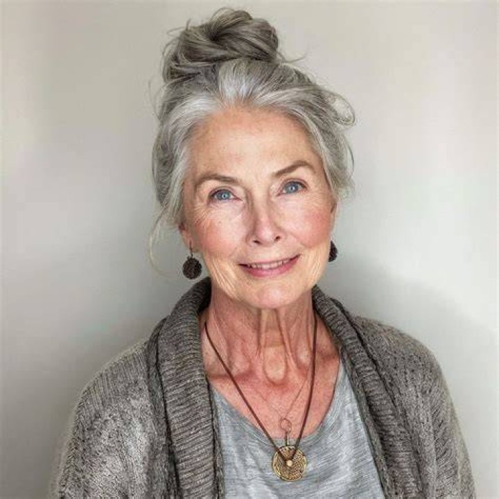older woman with gray hair sporting a sleek bun 