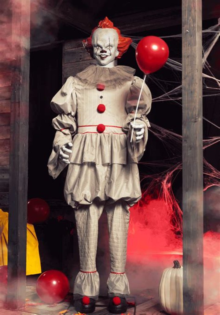 Pennywise the Dancing Clown holding a balloon and smiling in It