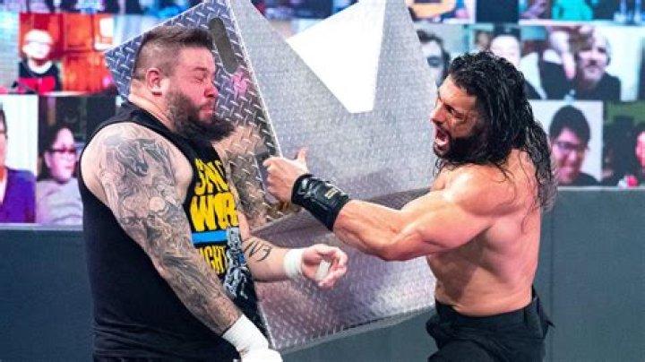 Roman Reigns hits Kevin Owens with a golf cart