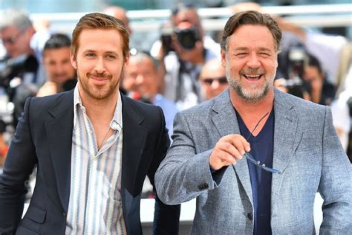 Ryan Gosling and Russell Crowe peer around a corner in The Nice Guys