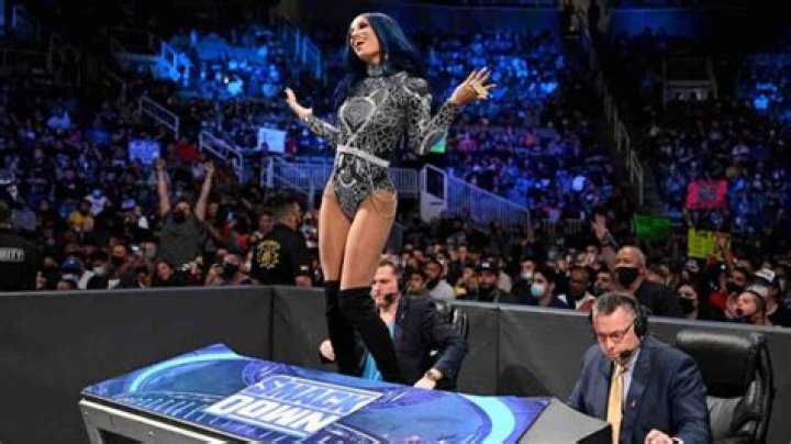 sasha banks standing on the smackdown announce desk