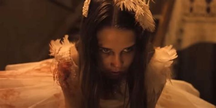 Tinatin Dalakishvili as Abigail wearing a white, bloody dress in Abigail