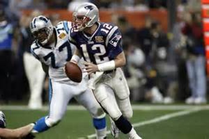 Tom Brady is chased by Carolina Panthers defensive tackle Kris Jenkins (77) during Super Bowl XXXVIII