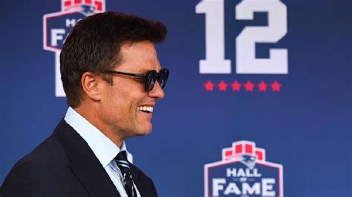 Tom smiles while wearing a suit in Succession.