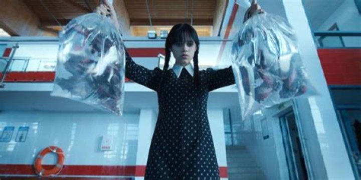 Wednesday holds bags of piranhas in episode 1