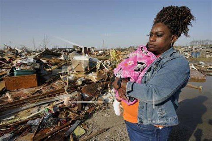 Wonder Bolden cradles her grand-daughter as she surveys the remains of her mother's tornado demolished mobile home. Photo / AP