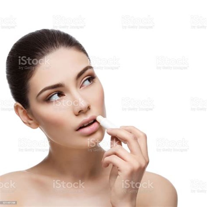 Young woman applying chapstick